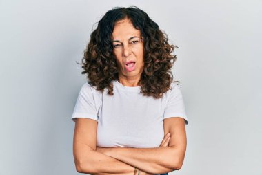 Orta yaşlı, kolları çapraz hareketli, budala ve kafası karışmış bir İspanyol kadın. şüphe kavramı. 