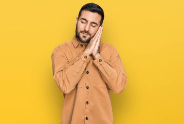 Gündelik kıyafetler giyen genç İspanyol adam uyur. Yorgun düşler kurar, ellerle poz verir, gözleri kapalı gülümserdi.. 