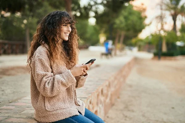 Νεαρή Ισπανόφωνη Γυναίκα Χαμογελά Ευτυχισμένη Χρησιμοποιώντας Smartphone Στο Πάρκο — Φωτογραφία Αρχείου