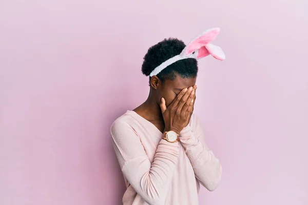 泣きながら手で顔を覆う悲しい表情でかわいいイースターバニーの耳を身に着けている若いアフリカ系アメリカ人の女の子 うつ病の概念 — ストック写真