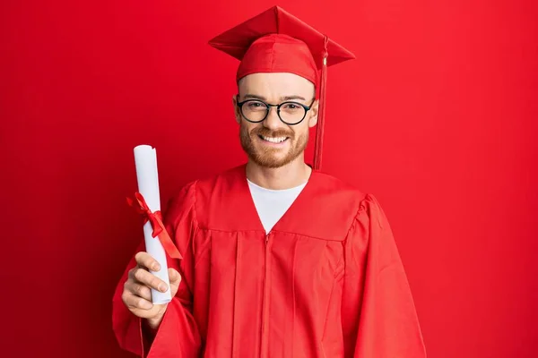 Mladý Zrzek Muž Sobě Maturitní Čepici Slavnostní Župan Drží Stupeň — Stock fotografie