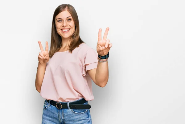 Krásná Běloška Neformálním Oblečení Usmívá Dívá Kamery Ukazuje Prsty Znamení — Stock fotografie