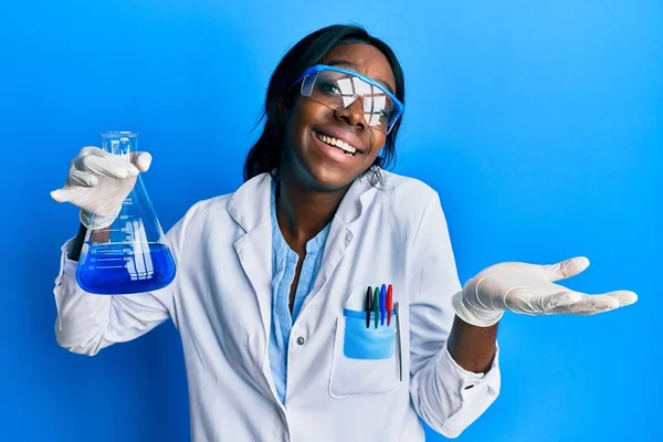 Joven Mujer Afroamericana Vistiendo Uniforme Científico Sosteniendo Tubo Ensayo Celebrando —  Fotos de Stock