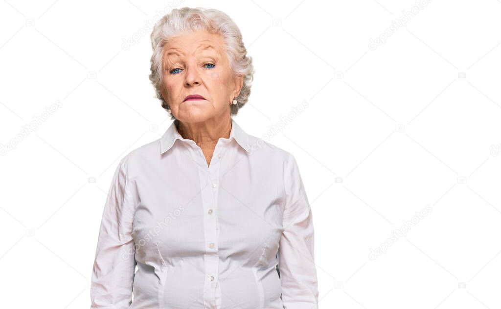 Senior grey-haired woman wearing casual clothes relaxed with serious expression on face. simple and natural looking at the camera. 