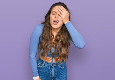 Latin asıllı genç bir kız günlük kıyafetler giyiyor. Yarı yüz, yarı göz, yarı ağız, yarı el esneme yorgunu. Yüzüm acıyor.. 