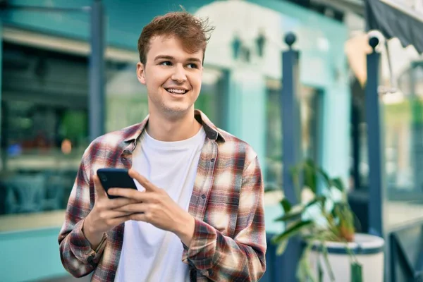 Joven Hombre Caucásico Sonriendo Feliz Usando Teléfono Inteligente Ciudad —  Fotos de Stock