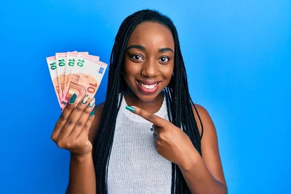 Mladá Africká Americká Žena Držící Eurobankovky Úsměvem Šťastně Ukazuje Rukou — Stock fotografie