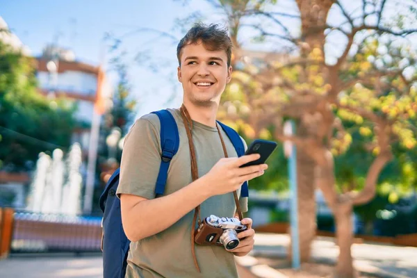 若い白人観光客の男笑顔幸せな使用スマートフォンで市内 — ストック写真