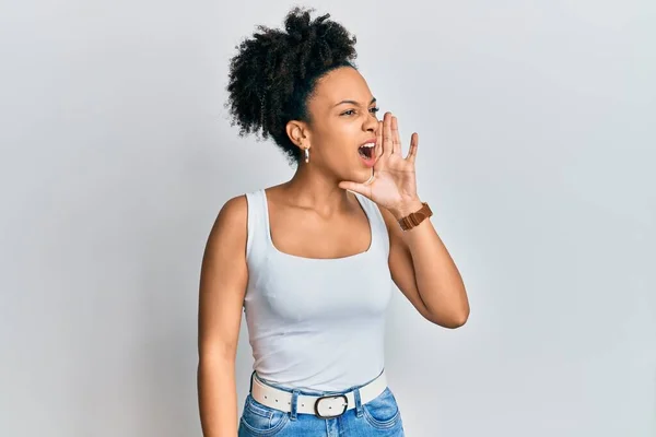 袖のないシャツを着た若いアフリカ系アメリカ人の女の子が大声で叫び 口の上で手で横に大声で叫んでいます コミュニケーションの概念 — ストック写真
