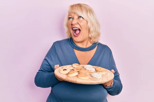 Blonde Frau Mittleren Alters Hält Tablett Mit Kuchen Bonbons Wütend — Stockfoto