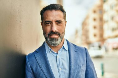 Orta yaşlı işadamı şehirde mutlu mesut dikilirken.