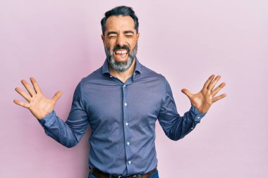 Orta yaşlı, sakallı, gri saçlı, iş kıyafetleri giyen, başarı için çıldıran, kollarını kaldırmış, gözlerini kapatmış heyecanlı çığlıklar atan bir adam. Kazanan konsept 