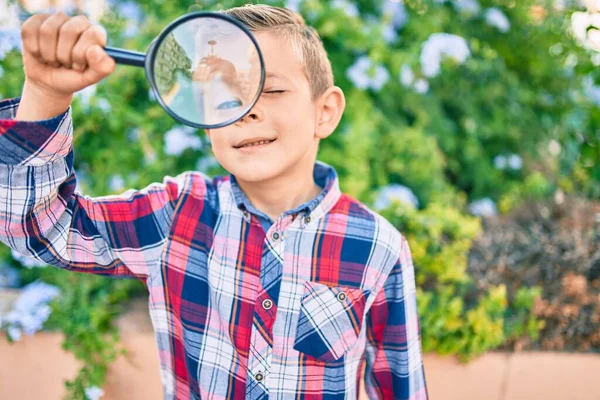 可爱的高加索探险家男孩在公园使用放大镜 — 图库照片