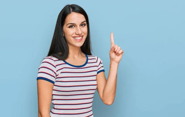 가볍게 무늬가 티셔츠를 자신감 행복하게 웃으면서 손가락으로 가리키는 스페인 — 스톡 사진