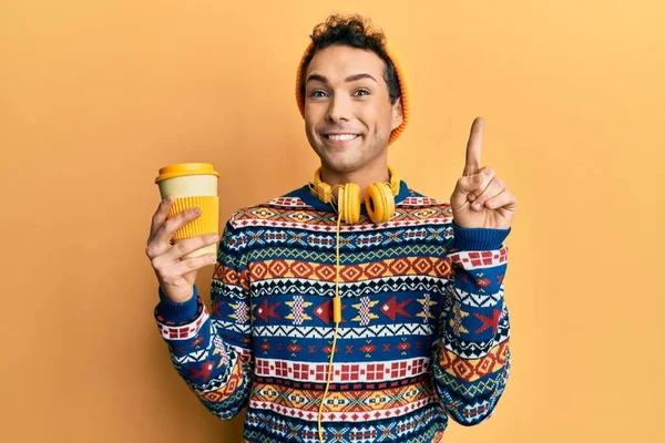 Mladý Pohledný Muž Pije Šálek Kávy Sluchátkách Usmívá Nápadem Nebo — Stock fotografie