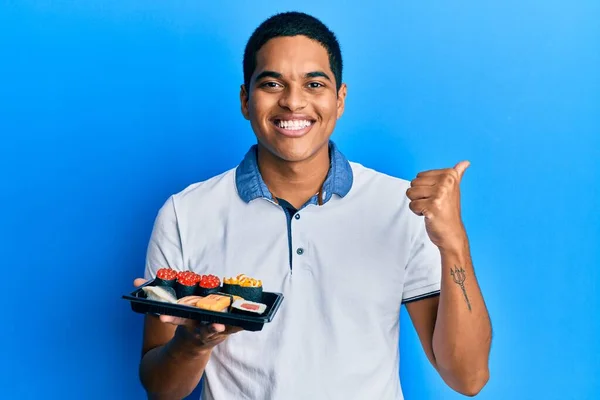 Joven Hombre Hispano Guapo Mostrando Plato Sushi Sonriendo Feliz Positivo — Foto de Stock