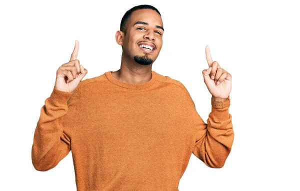 若いアフリカ系アメリカ人の男性は カジュアルな服を着て笑顔と驚きと指で指摘し 腕を上げ — ストック写真