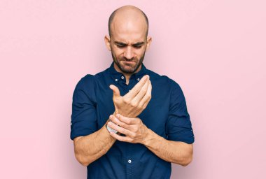 Günlük kıyafetler giyen genç İspanyol adam ellerinde ve parmaklarında ağrı, eklem iltihabı 