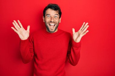 Sakallı, sıradan kırmızı kazak giyen yakışıklı adam çılgın kutlamalar yapıyor ve kolları açık, gözleri açık heyecanla haykırarak başarıya hayret ediyor. Kazanan konsept 