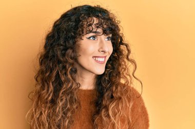 Latin kökenli genç bir kız, günlük giysiler giyiyor. Tarafını arıyor, profil pozu veriyor. Doğal bir yüz ve kendine güvenen bir gülümseme.. 