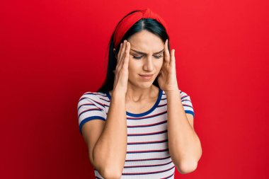 Genç İspanyol kadın gündelik kıyafetler giyiyor. Baş ağrısı, çaresiz ve stresli. Ağrı ve migren yüzünden. Eller başının üstünde.. 