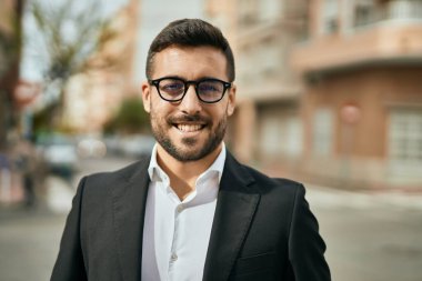 Genç İspanyol işadamı gülümseyerek şehirde mutlu mesut duruyor..