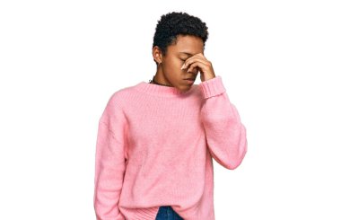 Genç Afro-Amerikan kadın günlük kıyafetler giyip yorgun burnu ve gözleri ovuşturup yorgun ve baş ağrısı çekiyor. Stres ve hüsran kavramı. 