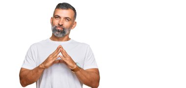 Orta yaşlı, yakışıklı, sıradan beyaz tişörtler giyen, gülümseyen, rahat ve neşeli bir adam. Başarı ve iyimserlik 