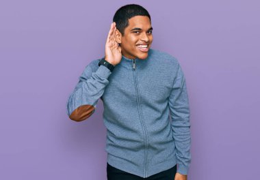 Genç, yakışıklı, sıradan bir kazak giyen, ağzı kulaklarında, dedikoduları ve dedikoduları dinleyen bir İspanyol. Sağırlık kavramı. 