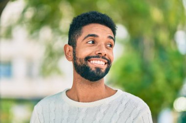 Genç Afrikalı Amerikalı adam parkta mutlu bir şekilde dikiliyor..