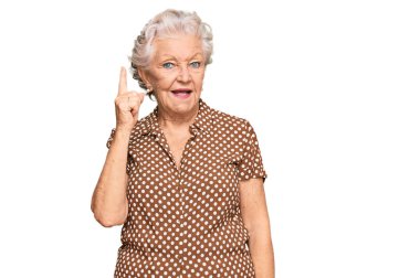 Gri saçlı, günlük kıyafetler giyen yaşlı bir kadın başarılı bir fikri işaret ediyor. Heyecanlı ve mutlu. Bir numara.. 