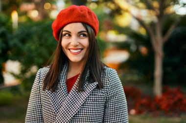 Genç İspanyol kadın gülümseyerek şehirde mutlu mesut dikiliyor..