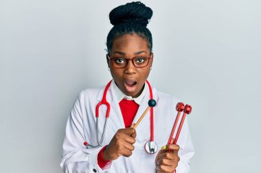 Genç Afro-Amerikan kadın doktor üniforması giyiyor elinde çatal tutuyordu. Korkuyordu ve şok olmuştu.. 