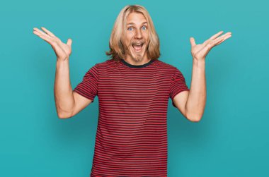 Sarışın, uzun saçlı, sıradan çizgili tişörtler giyen beyaz bir adam çılgın kutlamalar yapıyor ve kolları havada ve gözleri açık bir şekilde heyecanla haykırıyor. Kazanan konsept 