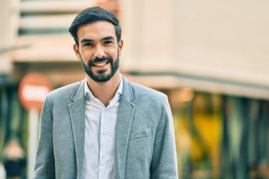 Genç İspanyol işadamı gülümseyerek şehirde mutlu mesut duruyor..