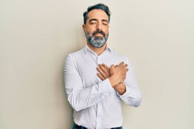 Orta yaşlı, sakallı, gri saçlı, sıradan beyaz tişörtlü, elleri göğsünde, gözleri kapalı, yüzünde minnet ifadesi olan bir adam. sağlık kavramı. 