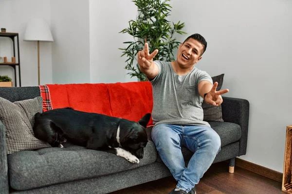Jovem Latino Homem Cão Sentado Sofá Casa Sorrindo Com Língua — Fotografia de Stock