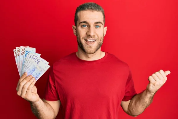 Молодий Білий Чоловік Тримає Шведські Банкноти Крони Вказуючи Великий Палець — стокове фото