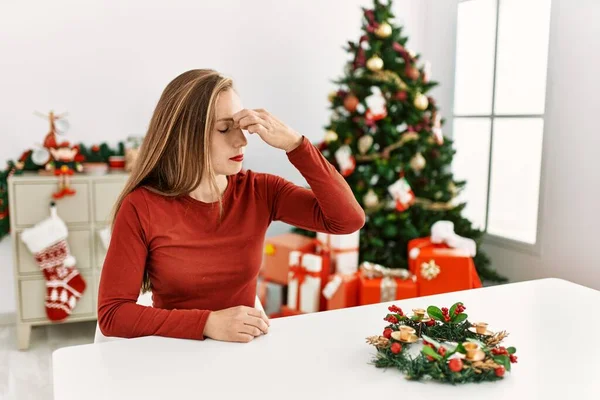 Kavkazská Mladá Blondýnka Sedící Stole Vánočního Stromku Unavená Třením Nosu — Stock fotografie