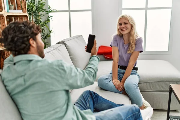 Jovem Fazendo Foto Sua Namorada Usando Smartphone Casa — Fotografia de Stock