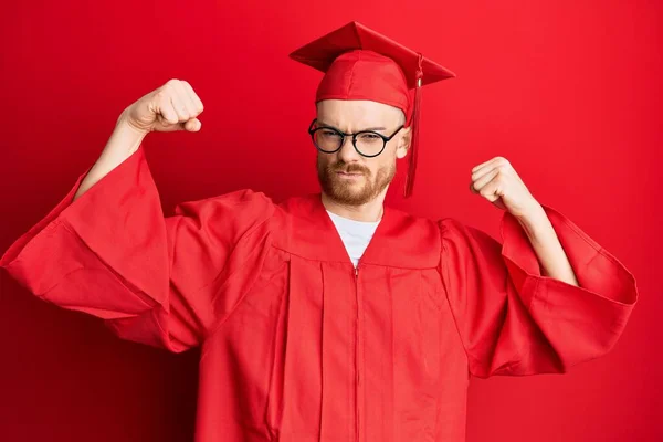Young Redhead Man Wearing Red Graduation Cap Ceremony Robe Showing — Stock Photo, Image