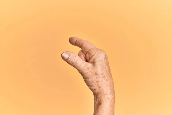 Senior Kaukasische Hand Gele Geïsoleerde Achtergrond Plukken Nemen Onzichtbare Ding — Stockfoto