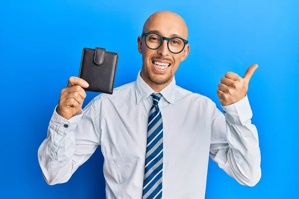 Hombre Calvo Con Barba Sosteniendo Cartera Cuero Apuntando Pulgar Hacia —  Fotos de Stock