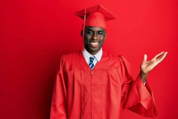 Молодий Афроамериканець Одягнений Випускний Кашкет Обрядовий Одяг Усміхається Радістю Вказує — стокове фото