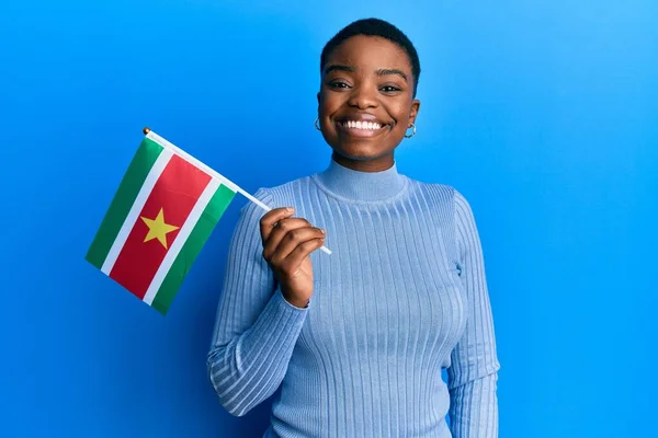 Ung Afrikansk Amerikansk Kvinna Håller Surinam Flagga Ser Positiv Och — Stockfoto