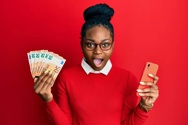 Joven Mujer Afroamericana Usando Teléfono Inteligente Con Billetes Euros Asustada —  Fotos de Stock