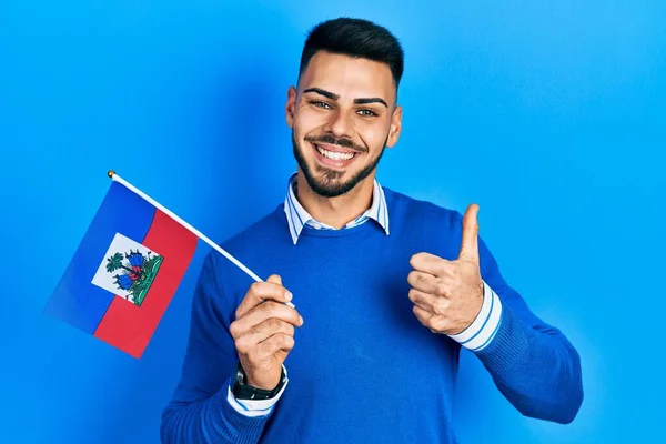 Joven Hombre Hispano Con Barba Sosteniendo Bandera Haití Sonriendo Feliz —  Fotos de Stock