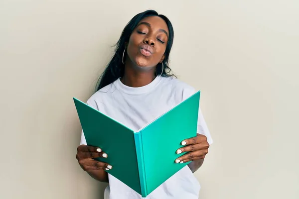 Joven Mujer Afroamericana Leyendo Libro Mirando Cámara Soplando Beso Siendo — Foto de Stock