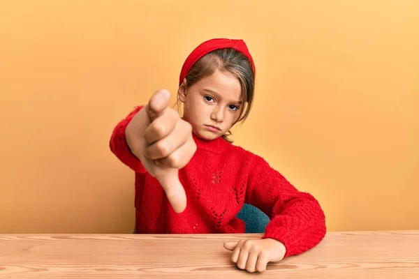 Klein Mooi Meisje Draagt Casual Kleren Zitten Tafel Kijken Ongelukkig — Stockfoto