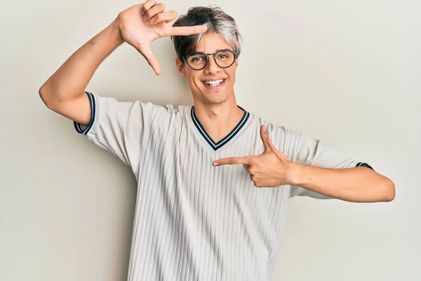 カジュアルな服や眼鏡を身に着けている若いヒスパニック系の男は幸せな顔で手や指でフレームを作り笑顔 創造性と写真の概念 — ストック写真